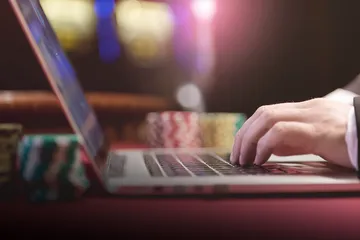 A professional dealer in a tuxedo greeting players at the roulette table, symbolizing the authentic live casino feel at JLWAFA88.